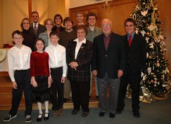 the 13 people in the church, next to a Christmas tree